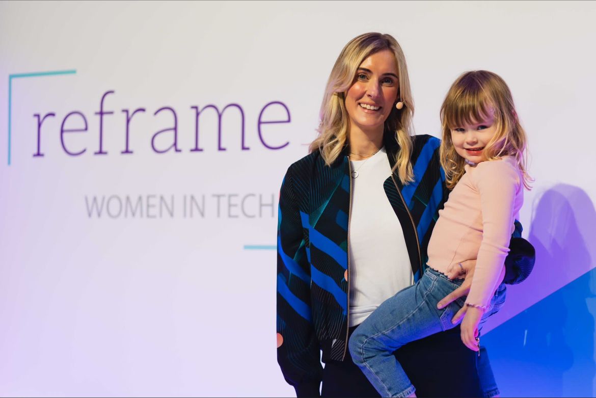 Beckie Taylor holding child at women in tech event